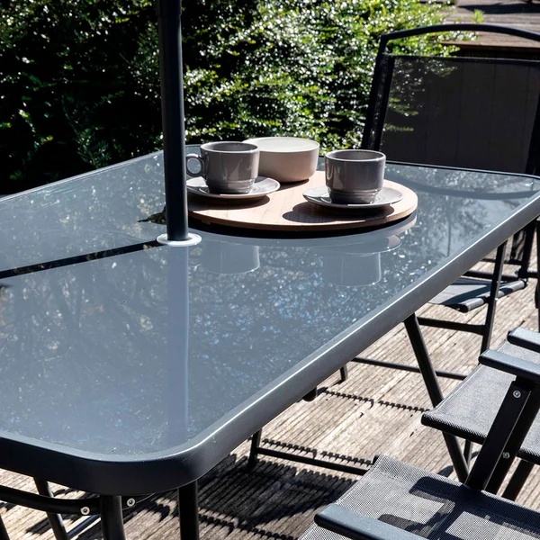 Ensemble table de jardin, 6 chaises et parasol central noir en acier 140x80cm - Braga